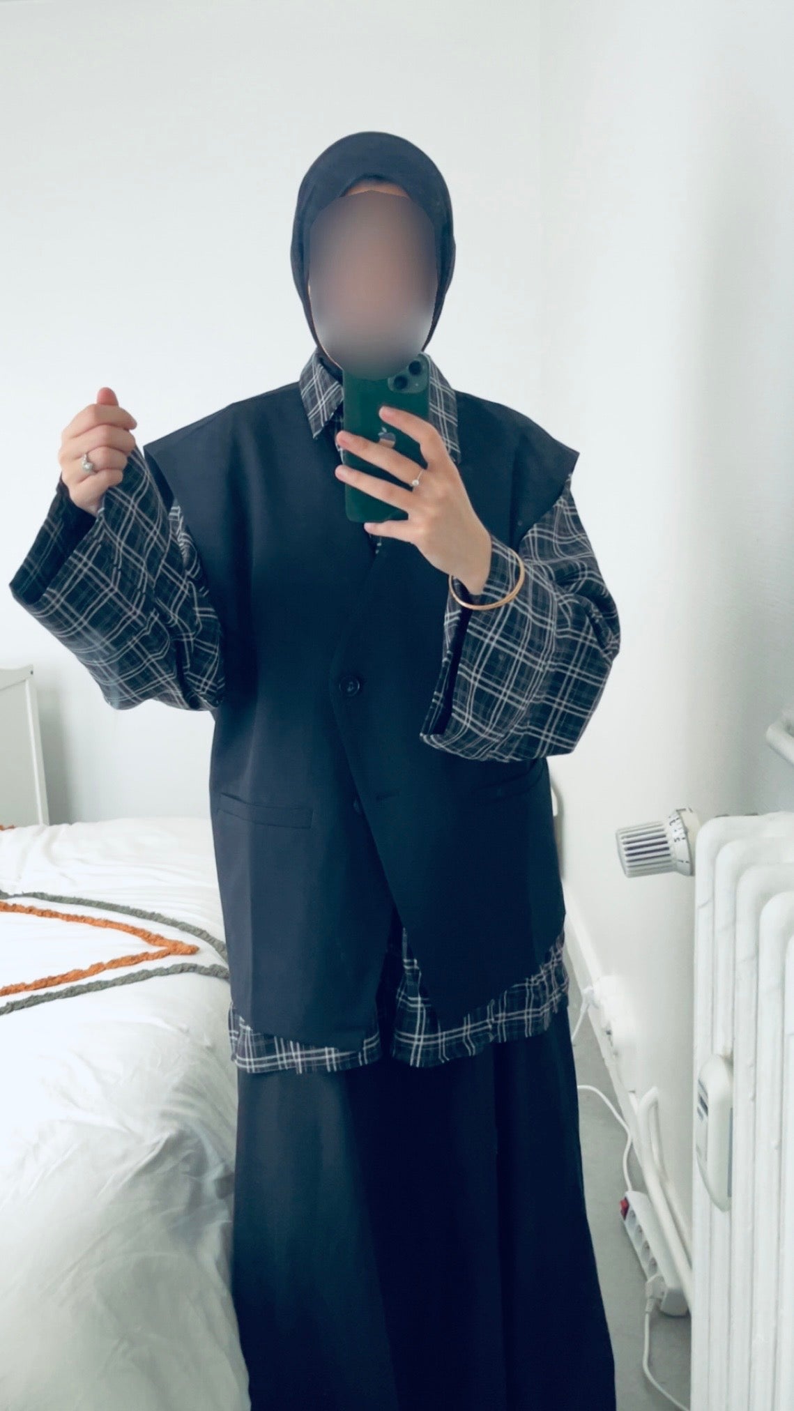 blazer oversize sans manches porté sur une tenue à carreaux, style moderne et décontracté